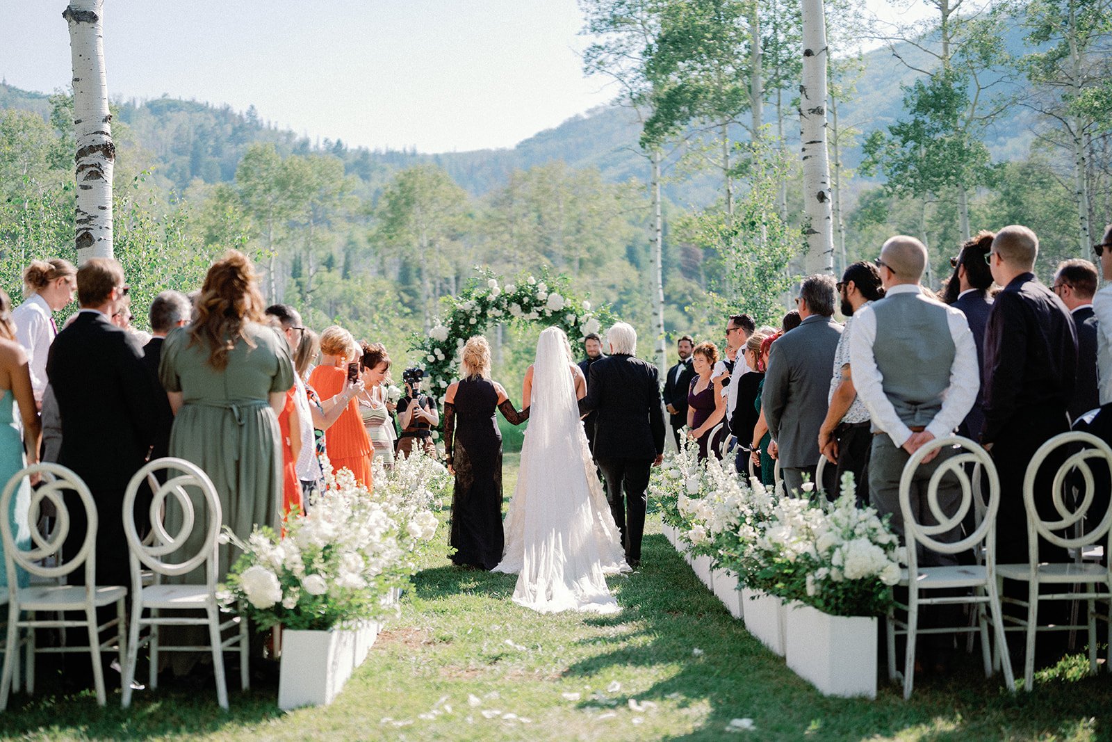 A garden ceremony aisle lined with celebrating guests